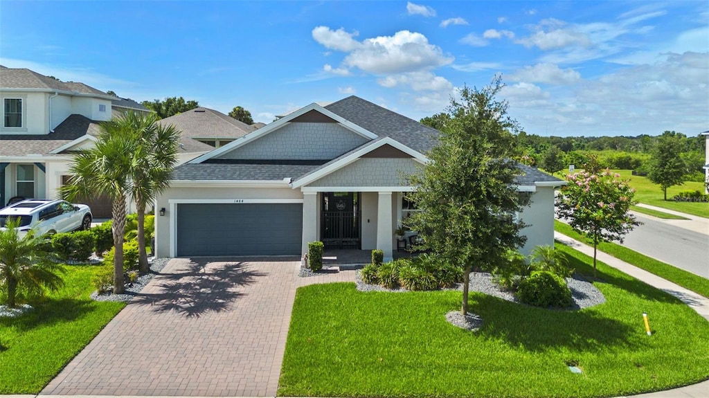 1484 Osprey View Dr, Apopka, FL 32703 - view of front of house with an attached garage, driveway, roof with shingles, a front yard, and stucco siding