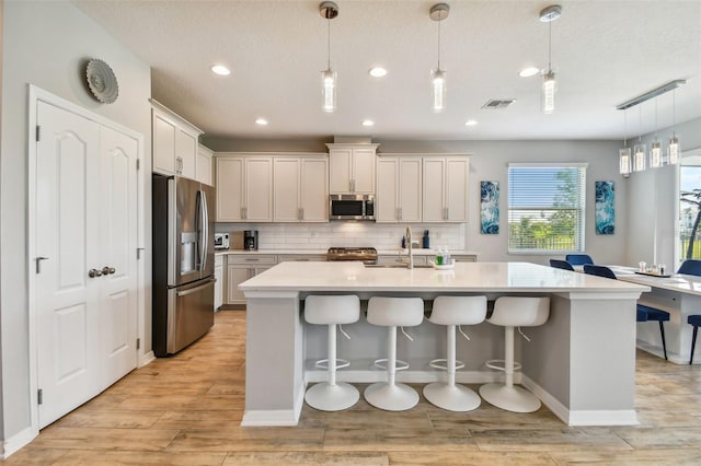 2433 Santa Vista Loop, Apopka, FL 32703 - kitchen with appliances with stainless steel finishes, light countertops, recessed lighting, backsplash, and light wood-type flooring