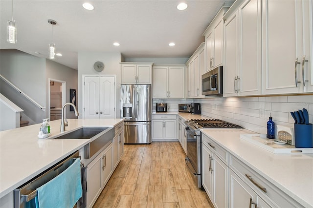 2433 Santa Vista Loop, Apopka, FL 32703 - kitchen with stainless steel appliances, pendant lighting, recessed lighting, light countertops, and light wood-type flooring