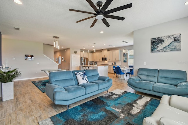 2433 Santa Vista Loop, Apopka, FL 32703 - living room with ceiling fan, light wood-style floors, recessed lighting, a chandelier, and a textured ceiling