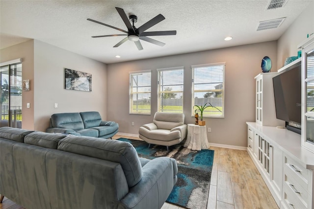 2433 Santa Vista Loop, Apopka, FL 32703 - living room with ceiling fan, light wood-style floors, a textured ceiling, plenty of natural light, and recessed lighting