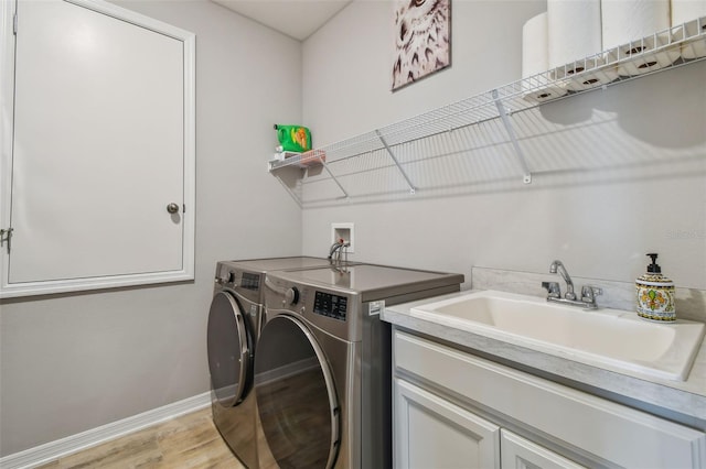 2433 Santa Vista Loop, Apopka, FL 32703 - laundry area with separate washer and dryer, light wood finished floors, and cabinet space