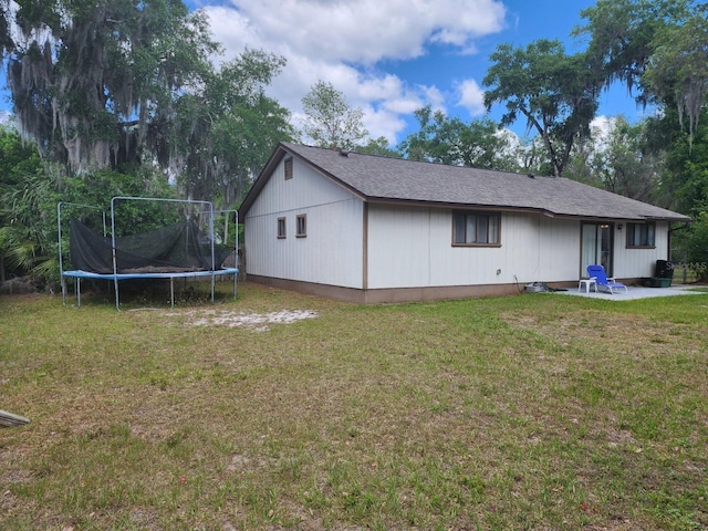 201 N Hart Rd, Geneva, FL 32732 - rear view of house with a trampoline, a lawn, and a patio