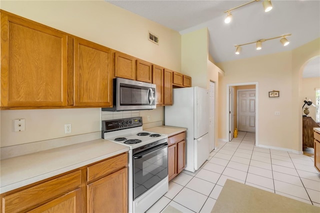 19 Potters Ln, Palm Coast, FL 32164 - kitchen featuring white appliances, arched walkways, light tile patterned floors, light countertops, and brown cabinetry
