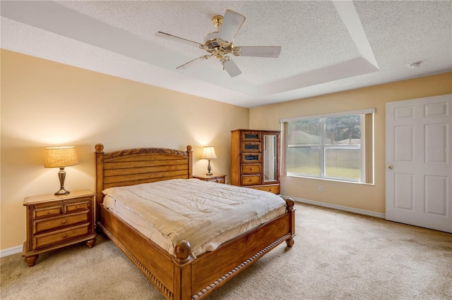 19 Potters Ln, Palm Coast, FL 32164 - bedroom with light colored carpet, a textured ceiling, a tray ceiling, and ceiling fan