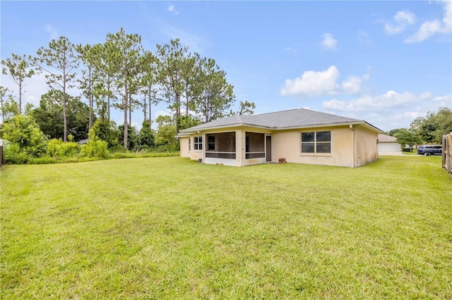 19 Potters Ln, Palm Coast, FL 32164 - back of house with a sunroom, a lawn, stucco siding, and a garage