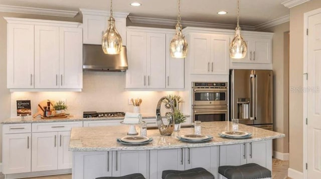 5295 Bowspirit Way, Saint Cloud, FL 34771 - kitchen featuring stainless steel appliances, wall chimney exhaust hood, a center island with sink, white cabinetry, and crown molding