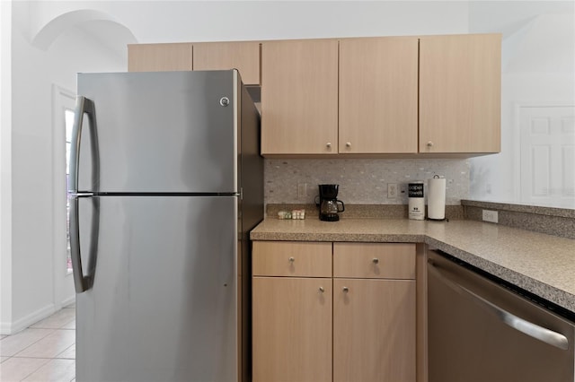 1176 S Beach Cir, Kissimmee, FL 34746 - kitchen featuring appliances with stainless steel finishes, light brown cabinetry, decorative backsplash, light tile patterned floors, and light countertops