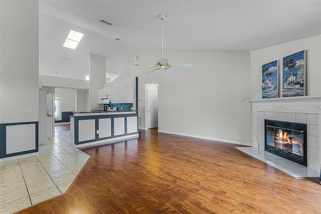 1326 Hampshire Place Cir, Altamonte Springs, FL 32714 - unfurnished living room with ceiling fan, a tile fireplace, high vaulted ceiling, and light wood-type flooring