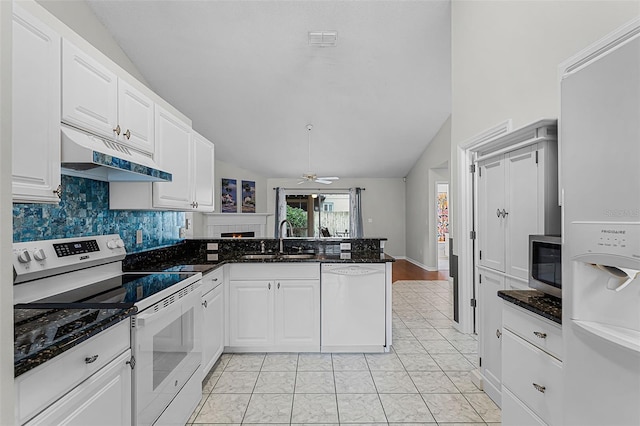 1326 Hampshire Place Cir, Altamonte Springs, FL 32714 - kitchen with white appliances, under cabinet range hood, vaulted ceiling, a peninsula, and white cabinetry