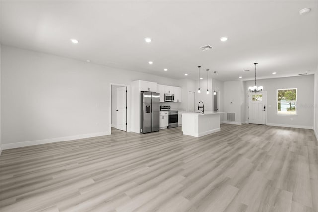 1970 SW 160th Pl, Ocala, FL 34473 - unfurnished living room featuring a chandelier, recessed lighting, and light wood-type flooring