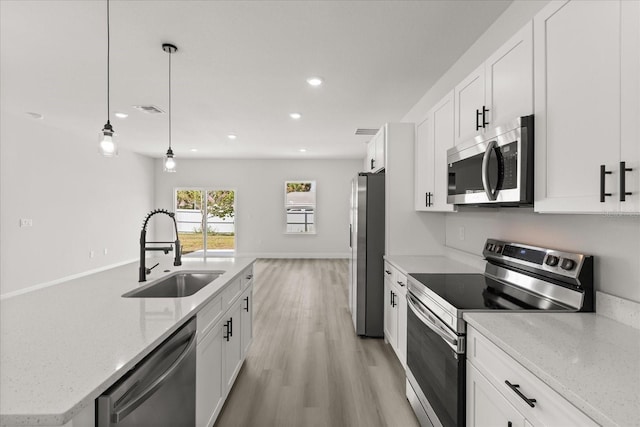 1970 SW 160th Pl, Ocala, FL 34473 - kitchen with stainless steel appliances, recessed lighting, white cabinetry, pendant lighting, and light wood-type flooring
