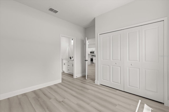 1970 SW 160th Pl, Ocala, FL 34473 - unfurnished bedroom with light wood-style flooring, a closet, and connected bathroom