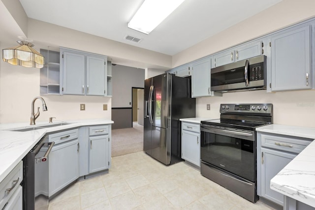 9001 New Orleans Ct, Orlando, FL 32818 - kitchen with appliances with stainless steel finishes, open shelves, light stone counters, and gray cabinetry