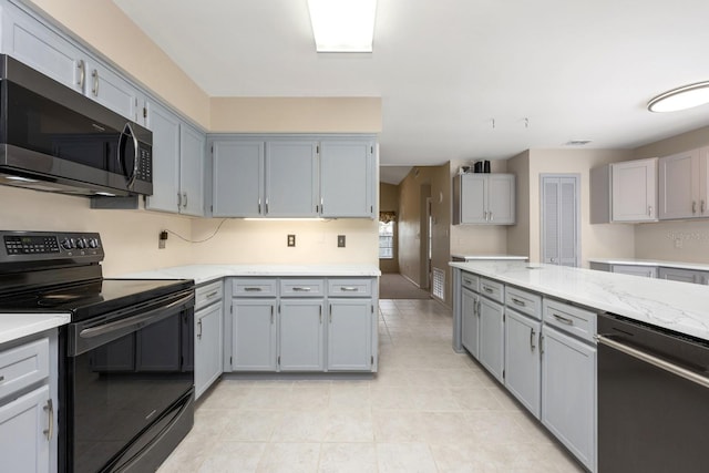 9001 New Orleans Ct, Orlando, FL 32818 - kitchen featuring appliances with stainless steel finishes, gray cabinetry, light tile patterned flooring, and light stone countertops