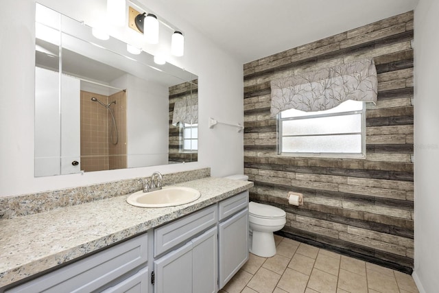 9001 New Orleans Ct, Orlando, FL 32818 - bathroom with wooden walls, vanity, tile patterned flooring, a tile shower, and healthy amount of natural light