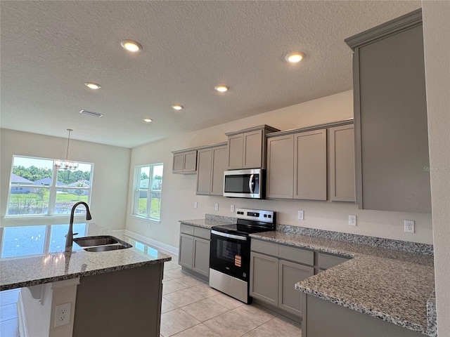 4113 Sagefield Dr, Harmony, FL 34773 - kitchen featuring appliances with stainless steel finishes, gray cabinetry, light stone counters, a chandelier, and recessed lighting