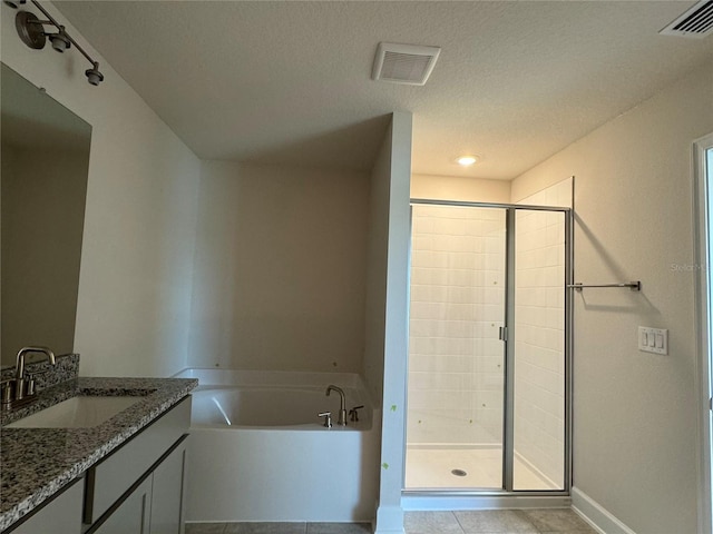 4113 Sagefield Dr, Harmony, FL 34773 - full bathroom featuring vanity, a bath, a shower stall, tile patterned flooring, and a textured ceiling
