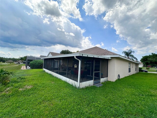 603 Reston Pl, Davenport, FL 33897 - back of property featuring a sunroom, a lawn, and stucco siding