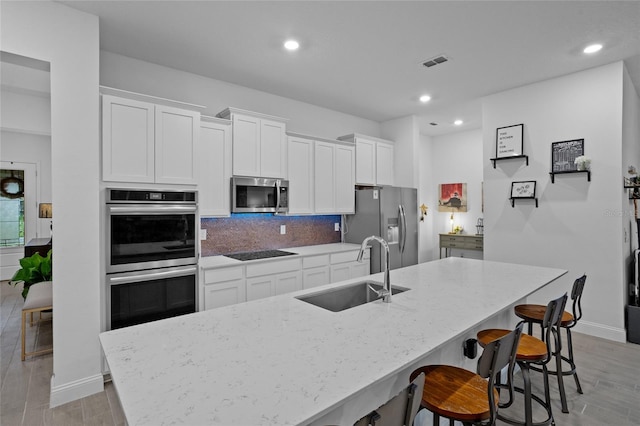 2149 Raglan Cir, Ormond Beach, FL 32174 - kitchen featuring appliances with stainless steel finishes, white cabinetry, recessed lighting, light stone countertops, and backsplash