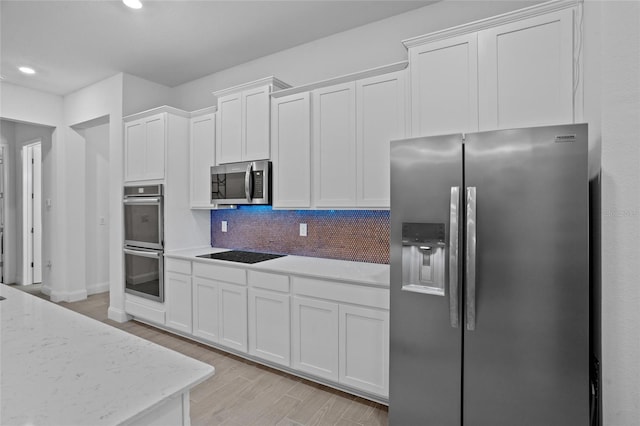 2149 Raglan Cir, Ormond Beach, FL 32174 - kitchen featuring appliances with stainless steel finishes, white cabinetry, light wood finished floors, decorative backsplash, and recessed lighting