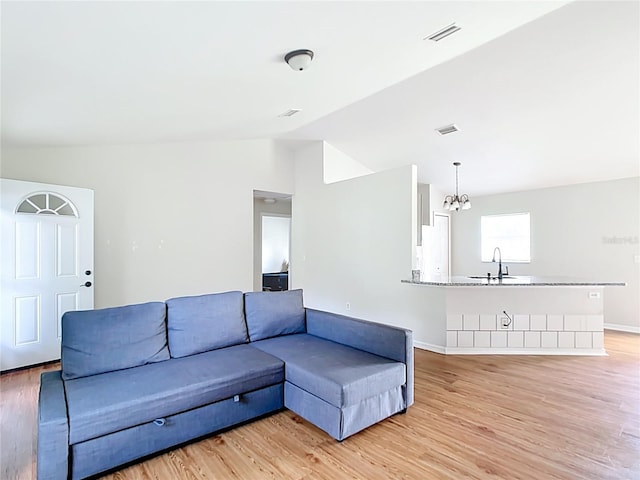 14939 SW 46th Cir, Ocala, FL 34473 - living room with vaulted ceiling, a chandelier, and light wood-style flooring
