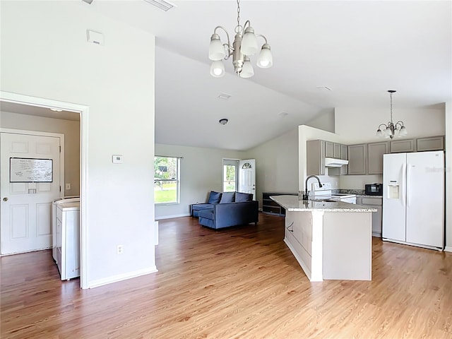 14939 SW 46th Cir, Ocala, FL 34473 - kitchen featuring white fridge with ice dispenser, a chandelier, open floor plan, under cabinet range hood, and gray cabinets