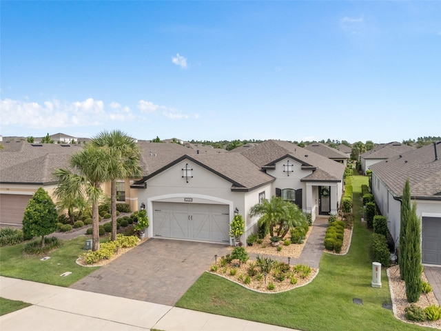2338 Clemblue Rd, Clermont, FL 34715 - view of front facade with stucco siding, a garage, driveway, a front lawn, and a shingled roof