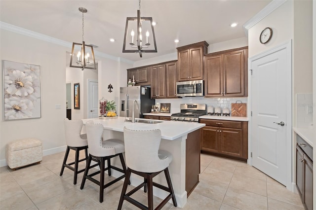 2338 Clemblue Rd, Clermont, FL 34715 - kitchen featuring stainless steel appliances, a chandelier, ornamental molding, light tile patterned floors, and a center island with sink