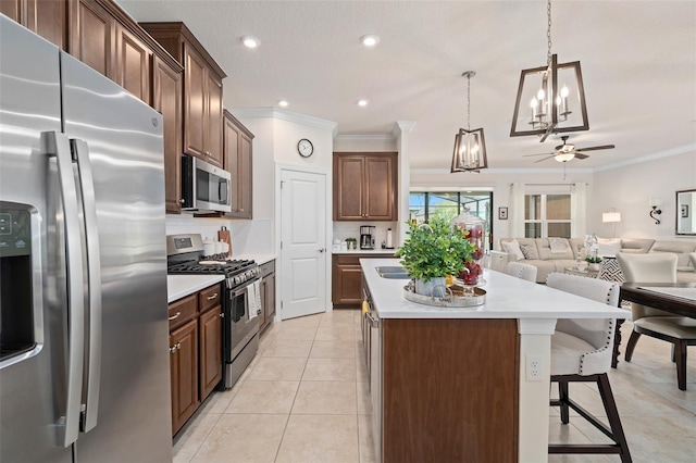 2338 Clemblue Rd, Clermont, FL 34715 - kitchen featuring stainless steel appliances, a center island, a chandelier, a ceiling fan, and ornamental molding