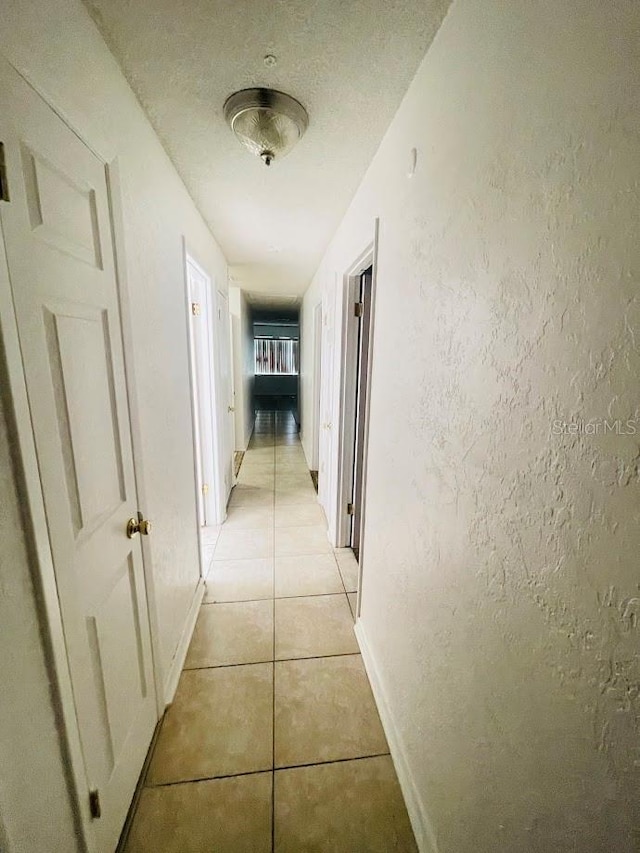 1980 Williams Manor Ave, Orlando, FL 32811 - corridor featuring light tile patterned floors and a textured wall