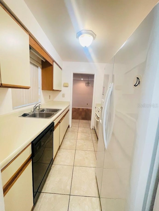 1980 Williams Manor Ave, Orlando, FL 32811 - kitchen with black dishwasher, light countertops, light tile patterned floors, and white cabinets