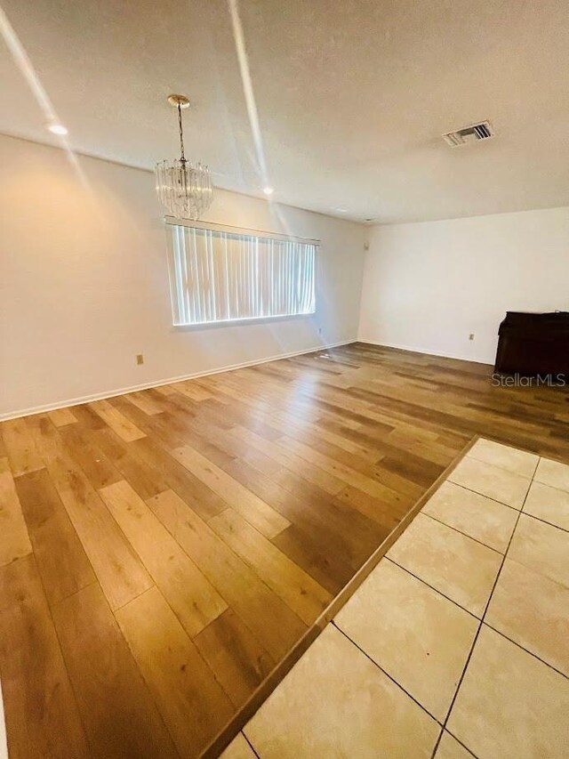 1980 Williams Manor Ave, Orlando, FL 32811 - empty room featuring light wood-style floors and a chandelier