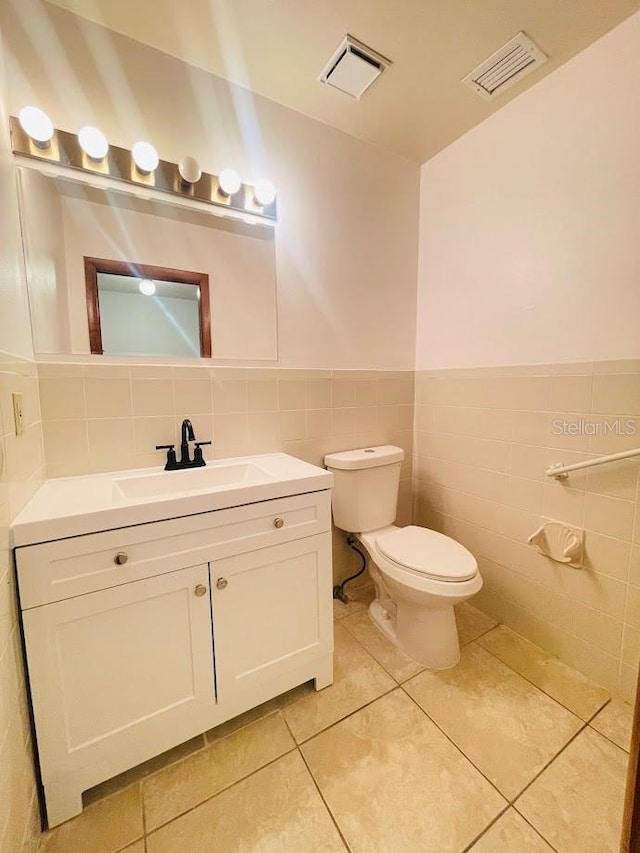 1980 Williams Manor Ave, Orlando, FL 32811 - half bathroom featuring vanity, tile patterned flooring, tile walls, and a wainscoted wall