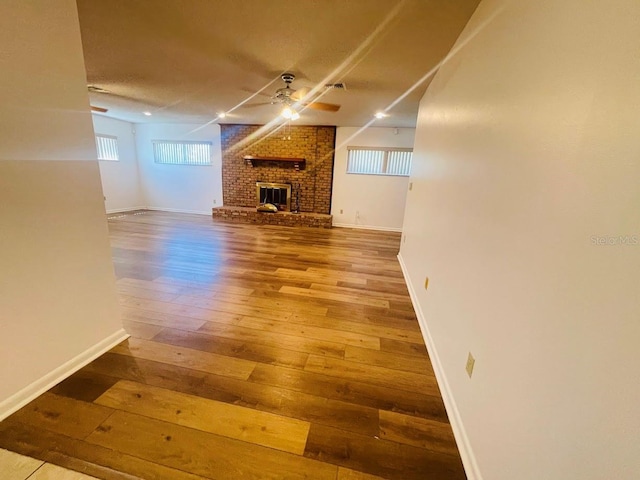1980 Williams Manor Ave, Orlando, FL 32811 - unfurnished living room featuring hardwood / wood-style floors, a fireplace, plenty of natural light, and a ceiling fan