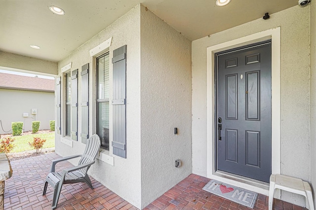 2647 Running Oak Ct, North Port, FL 34289 - property entrance with stucco siding, a surveillance system, and covered porch