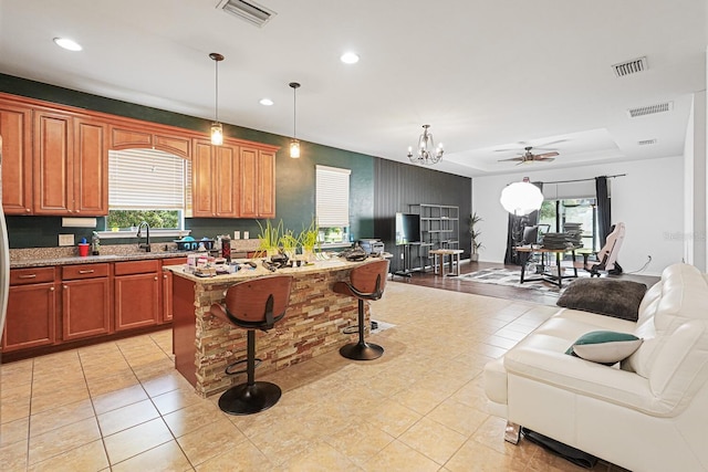 2647 Running Oak Ct, North Port, FL 34289 - kitchen featuring open floor plan, a kitchen bar, light tile patterned flooring, recessed lighting, and light stone counters