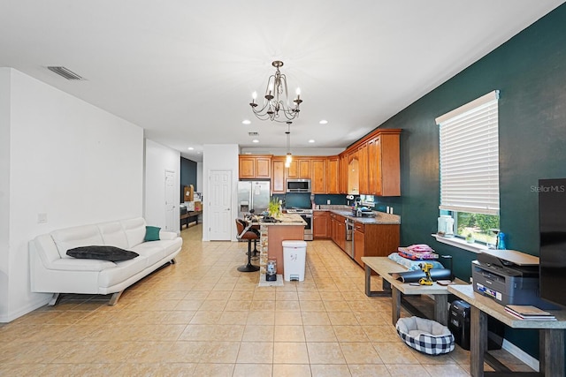 2647 Running Oak Ct, North Port, FL 34289 - kitchen with stainless steel appliances, a chandelier, a kitchen island, pendant lighting, and recessed lighting