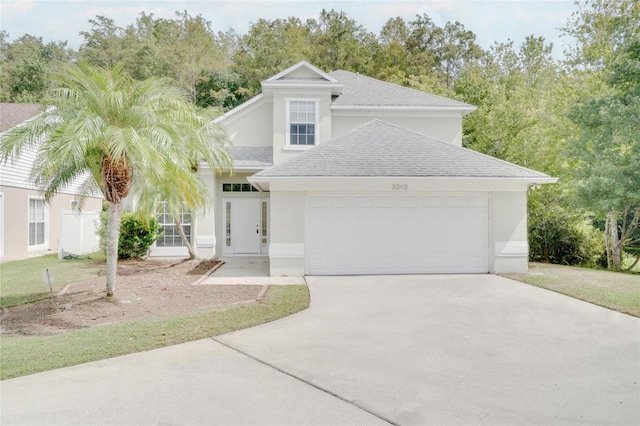 2262 Stonehedge Loop, Kissimmee, FL 34743 - view of front facade featuring an attached garage, driveway, roof with shingles, and stucco siding