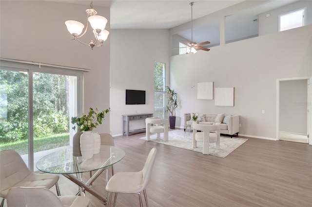 2262 Stonehedge Loop, Kissimmee, FL 34743 - dining area featuring a high ceiling, healthy amount of natural light, a ceiling fan, wood finished floors, and a chandelier