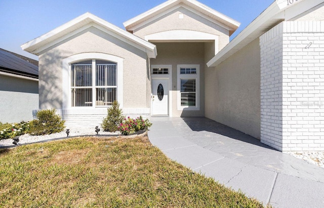 1041 Jaybee Ave, Davenport, FL 33897 - property entrance with stucco siding, brick siding, and a lawn