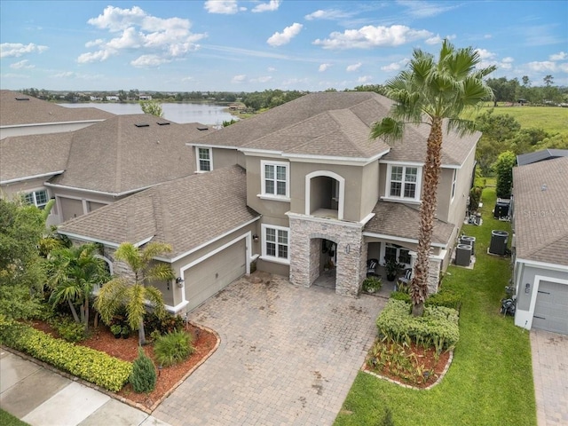 15264 Shonan Gold Dr, Winter Garden, FL 34787 - mediterranean / spanish-style home with stucco siding, stone siding, driveway, a shingled roof, and an attached garage