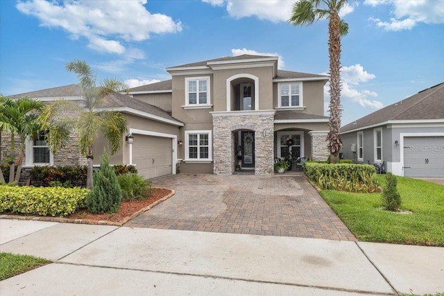 15264 Shonan Gold Dr, Winter Garden, FL 34787 - view of front of property featuring stucco siding, stone siding, decorative driveway, and a garage