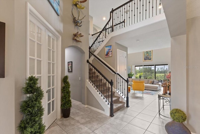 15264 Shonan Gold Dr, Winter Garden, FL 34787 - tiled foyer with a high ceiling, stairway, and arched walkways