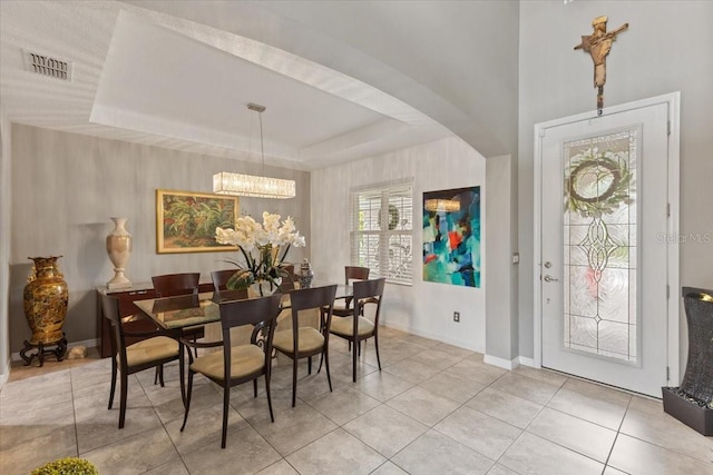 15264 Shonan Gold Dr, Winter Garden, FL 34787 - dining area featuring light tile patterned floors, a chandelier, arched walkways, and a raised ceiling