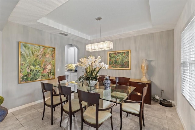 15264 Shonan Gold Dr, Winter Garden, FL 34787 - dining space featuring a raised ceiling, a chandelier, light tile patterned floors, and arched walkways