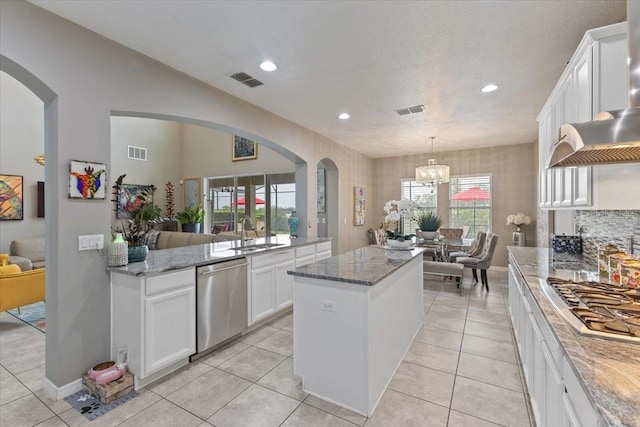 15264 Shonan Gold Dr, Winter Garden, FL 34787 - kitchen with stainless steel appliances, a center island, arched walkways, a chandelier, and white cabinets