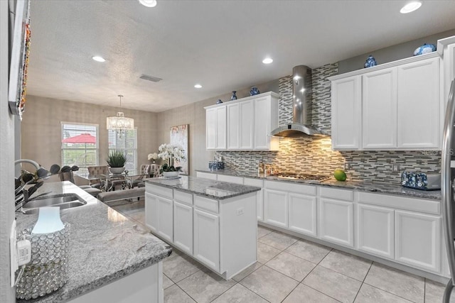 15264 Shonan Gold Dr, Winter Garden, FL 34787 - kitchen with wall chimney exhaust hood, a center island, a chandelier, backsplash, and white cabinets