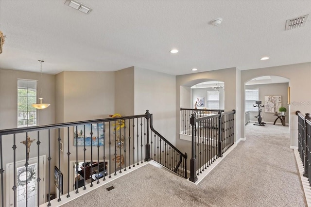 15264 Shonan Gold Dr, Winter Garden, FL 34787 - hallway with an upstairs landing, carpet, arched walkways, a textured ceiling, and recessed lighting