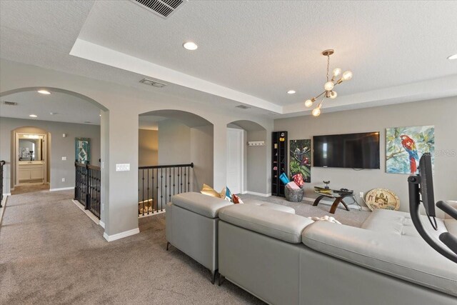 15264 Shonan Gold Dr, Winter Garden, FL 34787 - living area with light colored carpet, a tray ceiling, arched walkways, recessed lighting, and a chandelier